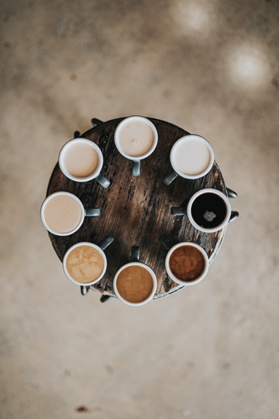 top-down view of 8 cups of coffee, of differing shades of brown
