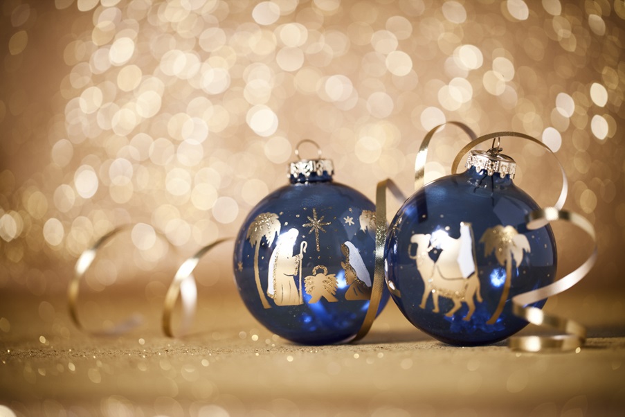 istock image of two christmas baubles decorated with nativity images - Mary and Joseph praying over baby Jesus; a Wise Man riding on a camel. 