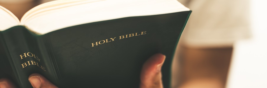 Man holding an open bible with one hand