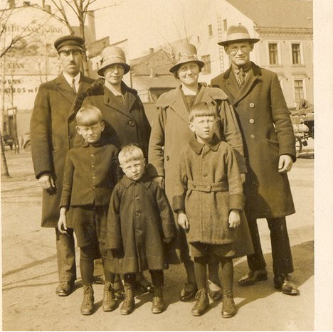 An old picture of the Wells family standing outside in their warm coats.