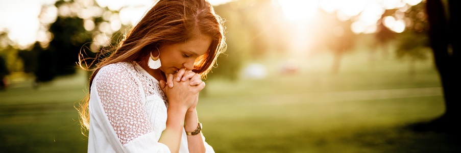 Woman in a field, praying