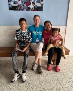A lady sitting on a bench with a family