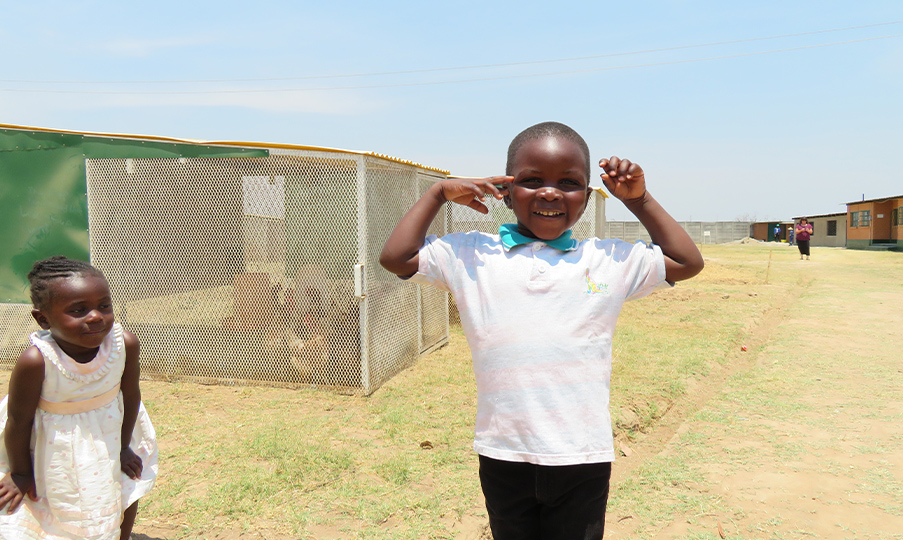 Little boy in a white polo shirt and little girl in a white dress smiling and playing